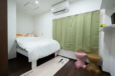 a small bedroom with a bed with a green curtain at \u738b101\u6574\u5957\u79c1\u4eba\u7a7a\u95f4\u72ec\u7acb\u536b\u6d74\u53a8\u623f \u6d17\u8863\u673a \u8f66\u7ad9\u6b65\u884c5\u5206\u949f \u4e0a\u91ce\u7ad9\u5730\u94c1\u76f4\u8fbe in Tokyo