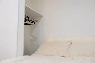 a bedroom with a bed in a white room at \u738b101\u6574\u5957\u79c1\u4eba\u7a7a\u95f4\u72ec\u7acb\u536b\u6d74\u53a8\u623f \u6d17\u8863\u673a \u8f66\u7ad9\u6b65\u884c5\u5206\u949f \u4e0a\u91ce\u7ad9\u5730\u94c1\u76f4\u8fbe in Tokyo