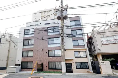 an electricity pole in front of a building at RECO Waseda by Tranova in Tokyo