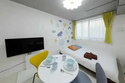 a bedroom with a bed and a table and a tv at RECO Waseda by Tranova in Tokyo