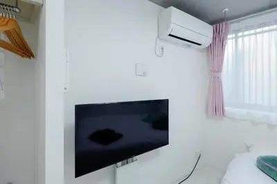 a living room with a flat screen tv on a wall at RECO Waseda by Tranova in Tokyo