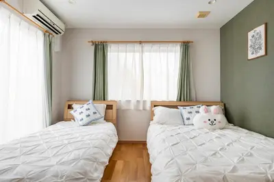 a bedroom with two beds and a stuffed animal on the pillows at hotel fleur-3F in Tokyo