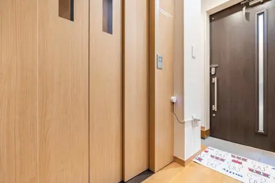a hallway with wooden doors and a rug next to a door at hotel fleur-3F in Tokyo