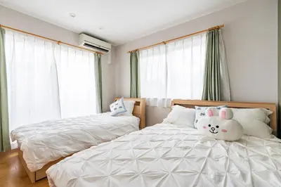 a bedroom with two beds and two windows at hotel fleur-3F in Tokyo