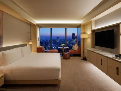 a bedroom with a large white bed and a television at Fairmont Tokyo in Tokyo