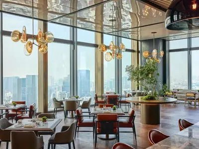 a restaurant with tables and chairs and large windows at Fairmont Tokyo in Tokyo