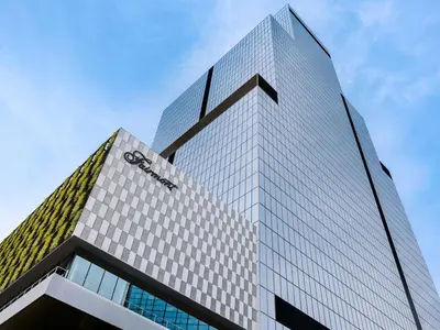 a tall glass building with a clock on it at Fairmont Tokyo in Tokyo