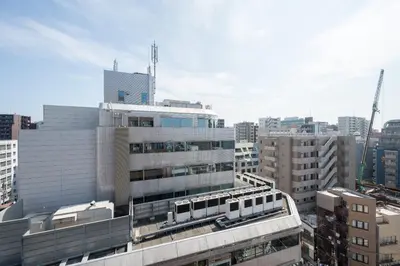 a tall building with a train on it in a city at \u30a2\u30eb\u30ab\u30c7\u30a3\u30a2\u897f\u84b2\u7530 in Tokyo