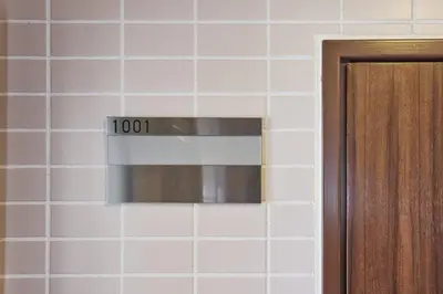 a sign on a tiled wall with a microwave at \u30a2\u30eb\u30ab\u30c7\u30a3\u30a2\u897f\u84b2\u7530 in Tokyo
