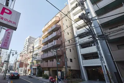 a city street with a tallartment building at \u30a2\u30eb\u30ab\u30c7\u30a3\u30a2\u897f\u84b2\u7530 in Tokyo