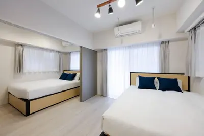 a bedroom with two beds with blue pillows at \u30ec\u30fc\u30f4\u6d45\u8349 in Tokyo