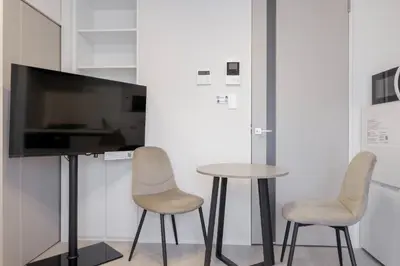two chairs and a table in a room with a tv at \u30ec\u30fc\u30f4\u6d45\u8349 in Tokyo
