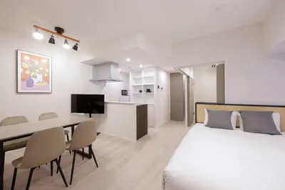 a bedroom with a bed and a table and a kitchen at \u30ec\u30fc\u30f4\u6d45\u8349 in Tokyo