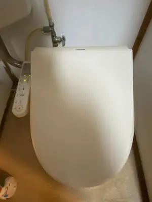 a white toilet in a room with a remote control at \u4ec1\u6e90\u548c in Tokyo