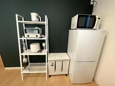 a microwave on top of a white refrigerator next to a microwave at jtr\u58a8\u75303\u4e01\u76ee in Tokyo