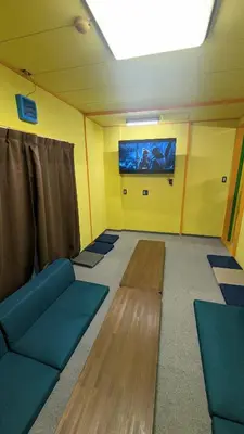 a room with couches and a tv on a wall at Joe Backpackers in Tokyo