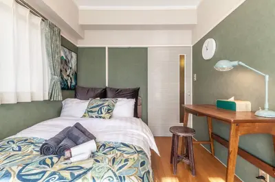 a bedroom with a bed and a wooden desk at \u30d5\u30b8\u30bf\u30ad\u30b3\u30fc\u30dd in Tokyo