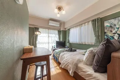 a bedroom with a bed and a desk with a computer at \u30d5\u30b8\u30bf\u30ad\u30b3\u30fc\u30dd in Tokyo
