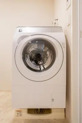 a white washing machine in a room with a door at Ken's Place Azabu-Juban in Tokyo