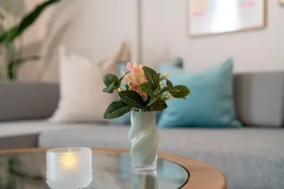 a vase with flowers sitting on a glass table at Ken's Place Azabu-Juban in Tokyo