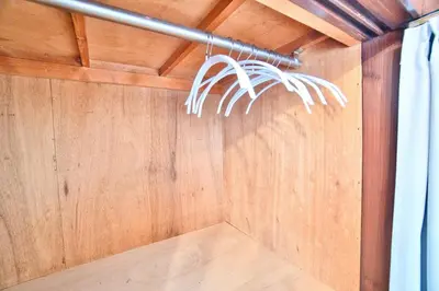 a room with a wood paneled wall and a curtain at Direct Shinjuku Max 10 Tokyo Hostel Shinozaki in Tokyo
