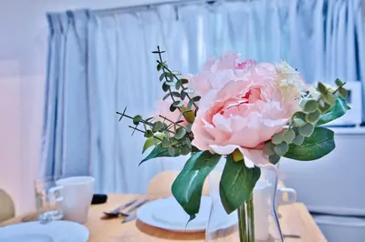 a vase filled with pink flowers on a table at Direct Shinjuku Max 10 Tokyo Hostel Shinozaki in Tokyo