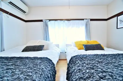 a bedroom with two beds and a window at Direct Shinjuku Max 10 Tokyo Hostel Shinozaki in Tokyo
