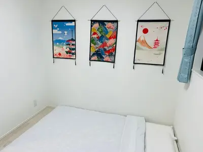 a bedroom with four pictures on the wall and a bed at A newly built house a 4 minute walk from the station, Free parking & Let's enjoy the night view together! in Tokyo