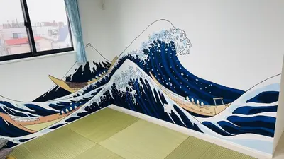 a mural of a wave on the wall of a room at A newly built house a 4 minute walk from the station, Free parking & Let's enjoy the night view together! in Tokyo