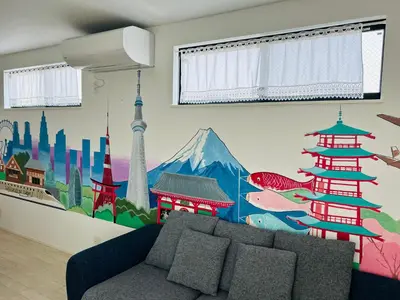 a living room with a couch and a mural on the wall at A newly built house a 4 minute walk from the station, Free parking & Let's enjoy the night view together! in Tokyo
