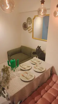a table with plates and a cat sitting on a couch at Stunning luxury APT with balcony in Tokyo Shinjuku Kabukicho in Tokyo