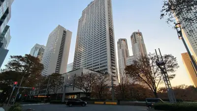 a car driving in a city with tall buildings at Stunning luxury APT with balcony in Tokyo Shinjuku Kabukicho in Tokyo
