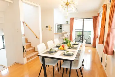 a dining room with a table and white chairs at 4 \u5367\u5ba4 - 3 \u6d74\u5ba4 - 3 \u536b\u751f\u95f4 - 100 \u5e73\u65b9 \u65b0\u88c5 \u522b\u5885 - \u65b0\u5bbf 4 \u5206\u949f - Sakura House in Tokyo