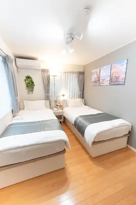 two beds in a bedroom with wooden floors at 4 \u5367\u5ba4 - 3 \u6d74\u5ba4 - 3 \u536b\u751f\u95f4 - 100 \u5e73\u65b9 \u65b0\u88c5 \u522b\u5885 - \u65b0\u5bbf 4 \u5206\u949f - Sakura House in Tokyo