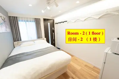 a bedroom with a bed and a sign on the wall at 4 \u5367\u5ba4 - 3 \u6d74\u5ba4 - 3 \u536b\u751f\u95f4 - 100 \u5e73\u65b9 \u65b0\u88c5 \u522b\u5885 - \u65b0\u5bbf 4 \u5206\u949f - Sakura House in Tokyo