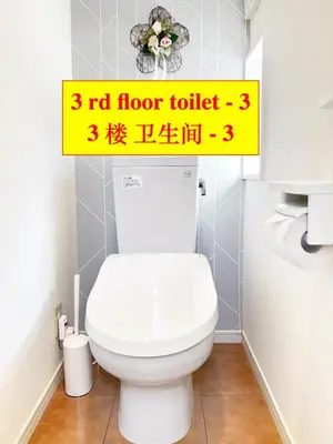 a bathroom with a toilet with a yellow sign above it at 4 \u5367\u5ba4 - 3 \u6d74\u5ba4 - 3 \u536b\u751f\u95f4 - 100 \u5e73\u65b9 \u65b0\u88c5 \u522b\u5885 - \u65b0\u5bbf 4 \u5206\u949f - Sakura House in Tokyo