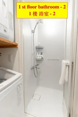 a bathroom with a shower with a sign on the door at 4 \u5367\u5ba4 - 3 \u6d74\u5ba4 - 3 \u536b\u751f\u95f4 - 100 \u5e73\u65b9 \u65b0\u88c5 \u522b\u5885 - \u65b0\u5bbf 4 \u5206\u949f - Sakura House in Tokyo