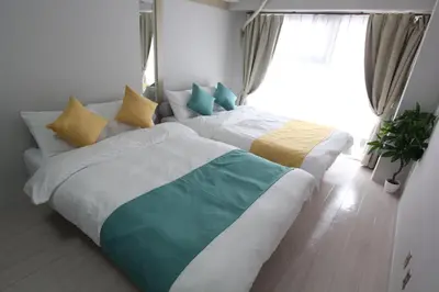 a bedroom with two beds and a window at LUANA in SHINJUKU in Tokyo