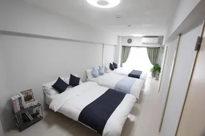 a bedroom with two beds and a window at LUANA in SHINJUKU in Tokyo