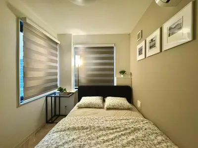 a bed in a bedroom with a window and a bedspread at ToYo House\u4ee3\u3005\u6728 in Tokyo