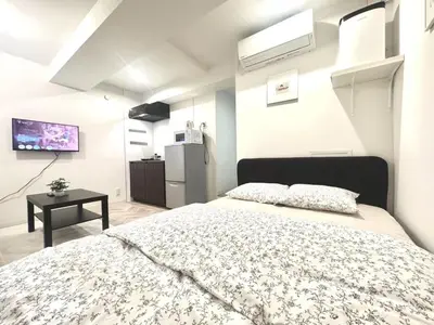 a bedroom with a large bed and a tv at ToYo House\u4ee3\u3005\u6728 in Tokyo