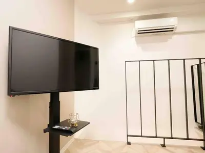a flat screen tv hanging on a wall at ToYo House\u4ee3\u3005\u6728 in Tokyo