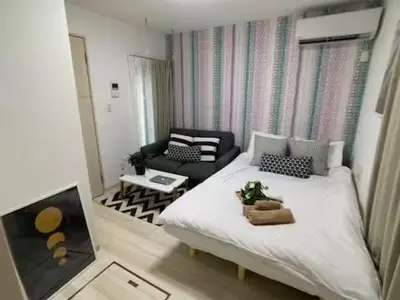 a small room with a bed and a couch at COMMA HOUSE Nishi-Ikebukuro 102 in Tokyo