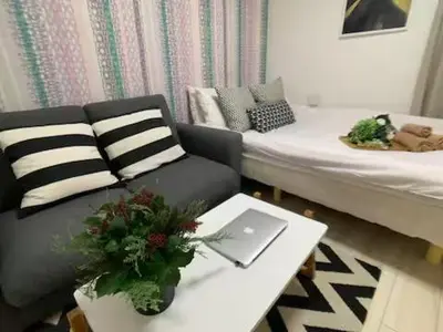 a living room with a bed and a couch and a table at COMMA HOUSE Nishi-Ikebukuro 102 in Tokyo