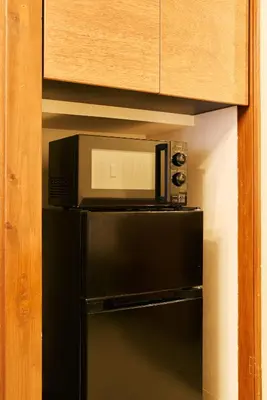 a microwave oven sitting on top of a refrigerator at \u4eac\u6210\u7acb\u77f3\u99c5 \u5f92\u6b6910\u5206 \u30b9\u30ab\u30a4\u30c4\u30ea\u30fc7\u5206 \u6d45\u834910\u5206 \u6700\u592710\u540d \u5bb6\u65cf\u6ede\u5728 \u7fbd\u7530\u6210\u7530\u7a7a\u6e2f\u76f4\u901a in Tokyo