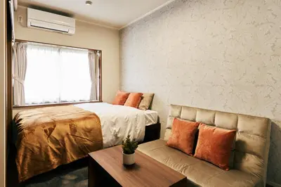 a bedroom with a bed and a couch and a window at \u4eac\u6210\u7acb\u77f3\u99c5 \u5f92\u6b6910\u5206 \u30b9\u30ab\u30a4\u30c4\u30ea\u30fc7\u5206 \u6d45\u834910\u5206 \u6700\u592710\u540d \u5bb6\u65cf\u6ede\u5728 \u7fbd\u7530\u6210\u7530\u7a7a\u6e2f\u76f4\u901a in Tokyo