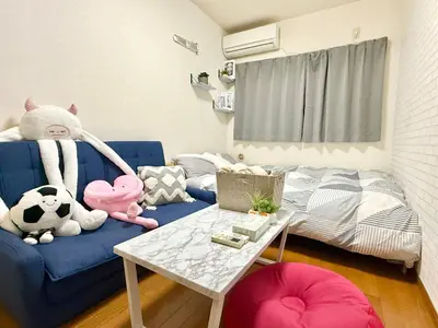 a room with a blue couch with stuffed animals and a bed at Shinjuku \u9ad8\u7530\u99ac\u5834T AC in Tokyo