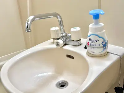 a bathroom sink with a bottle of soap and a toothbrush at Shinjuku \u9ad8\u7530\u99ac\u5834T AC in Tokyo