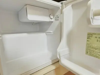 an empty refrigerator with its door open in a room at Shinjuku \u9ad8\u7530\u99ac\u5834T AC in Tokyo