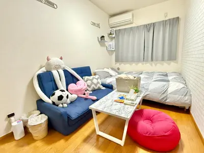 a room with a blue couch with a bed and a table at Shinjuku \u9ad8\u7530\u99ac\u5834T AC in Tokyo